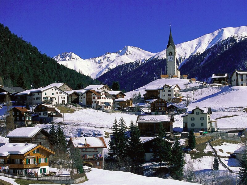 Snowy mountain village with church