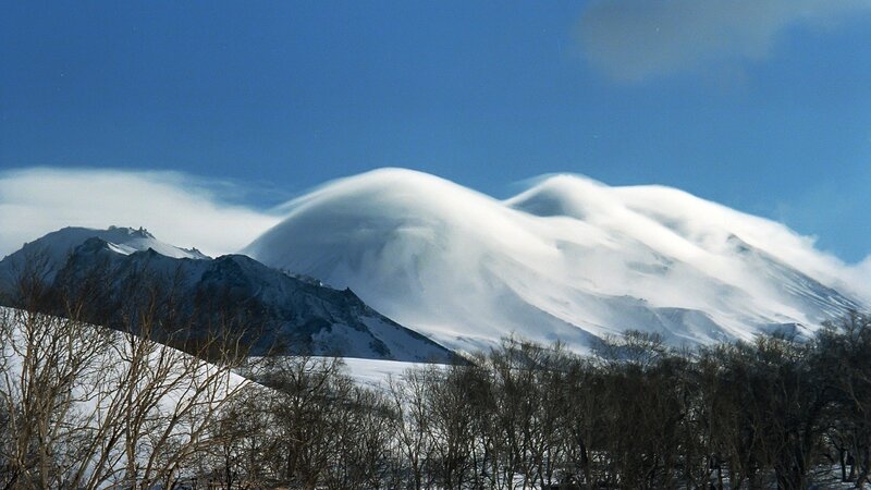 Snowy mountain with lenticular clouds
