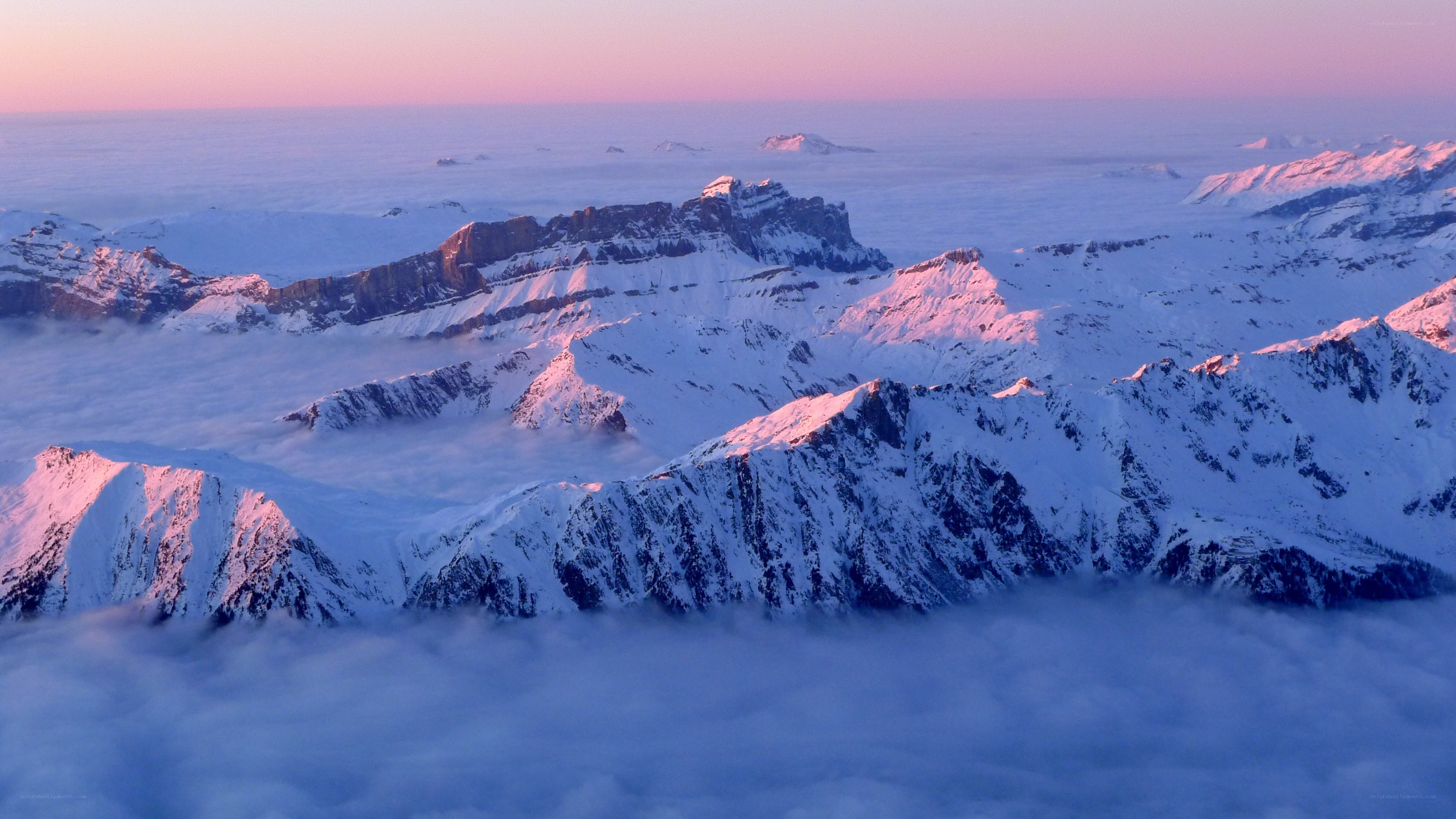 snowy mountains above clouds