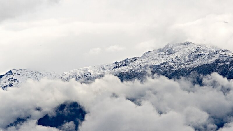 snowy mountains above clouds