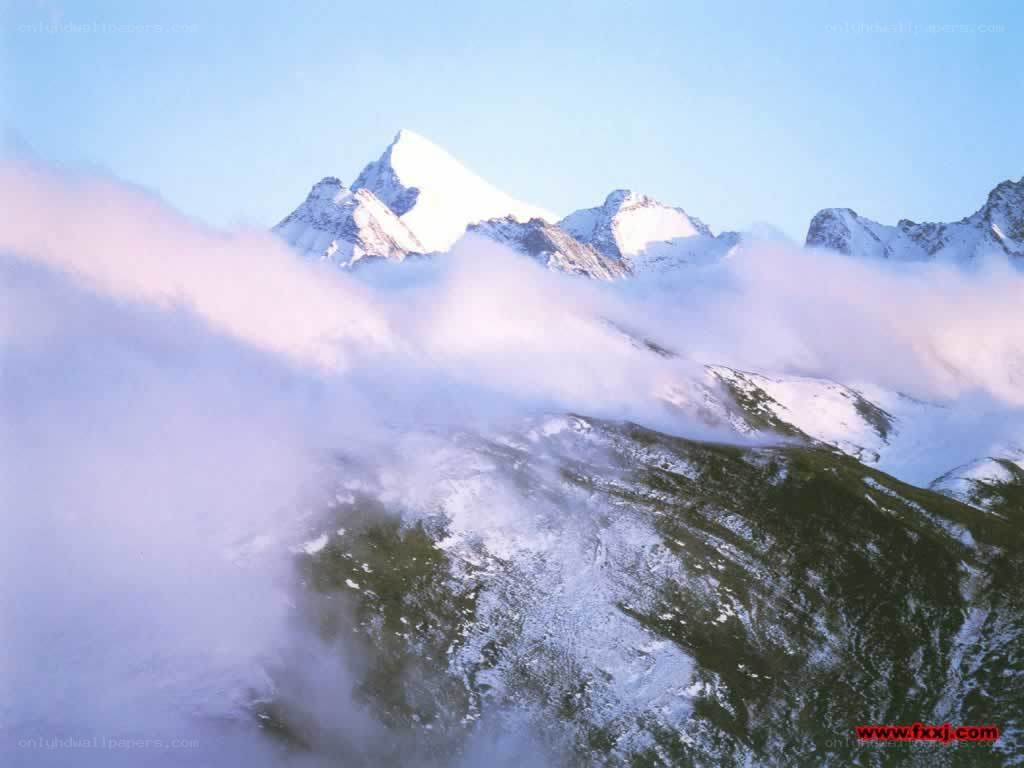Snowy mountains above clouds