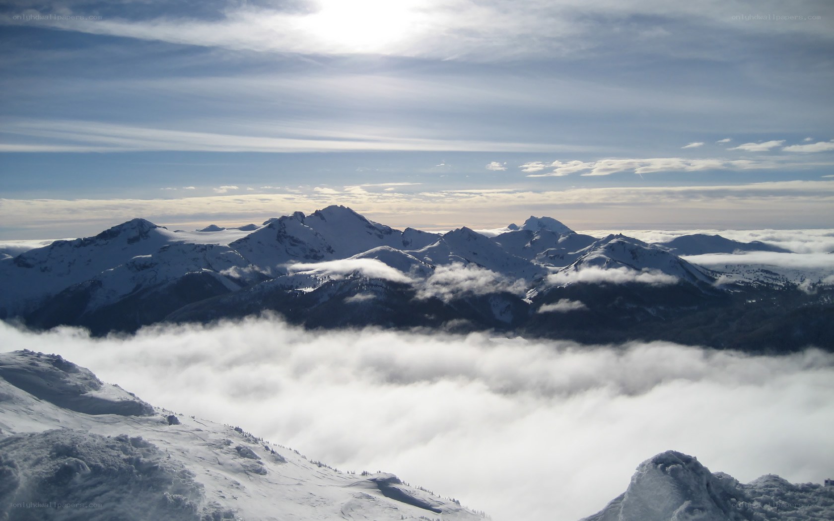 snowy mountains above clouds