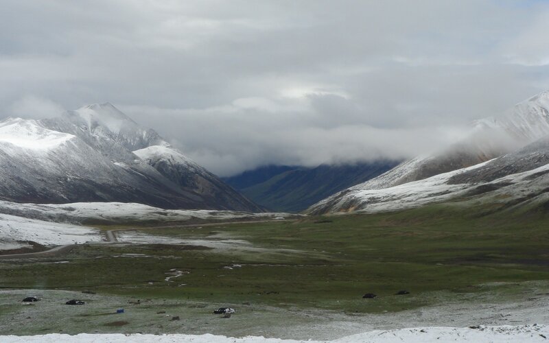 snowy mountains and green valley