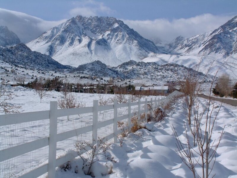 Snowy mountains and white fence