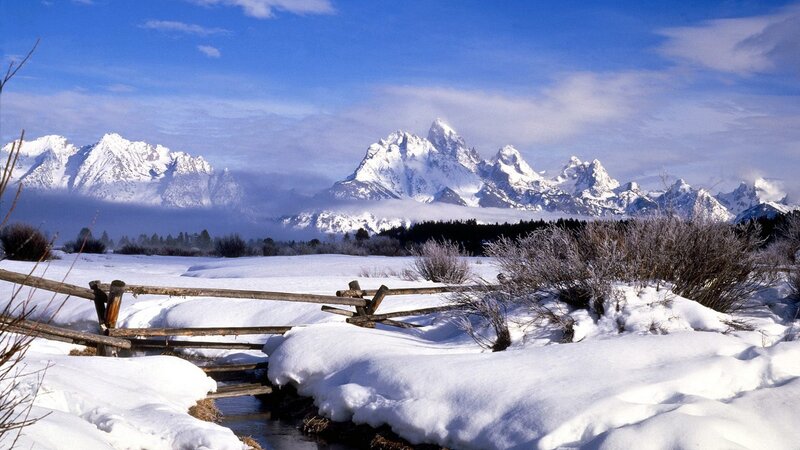 Snowy mountains and wooden fence