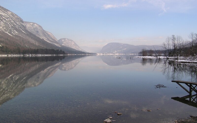 Snowy mountains reflect in calm lake