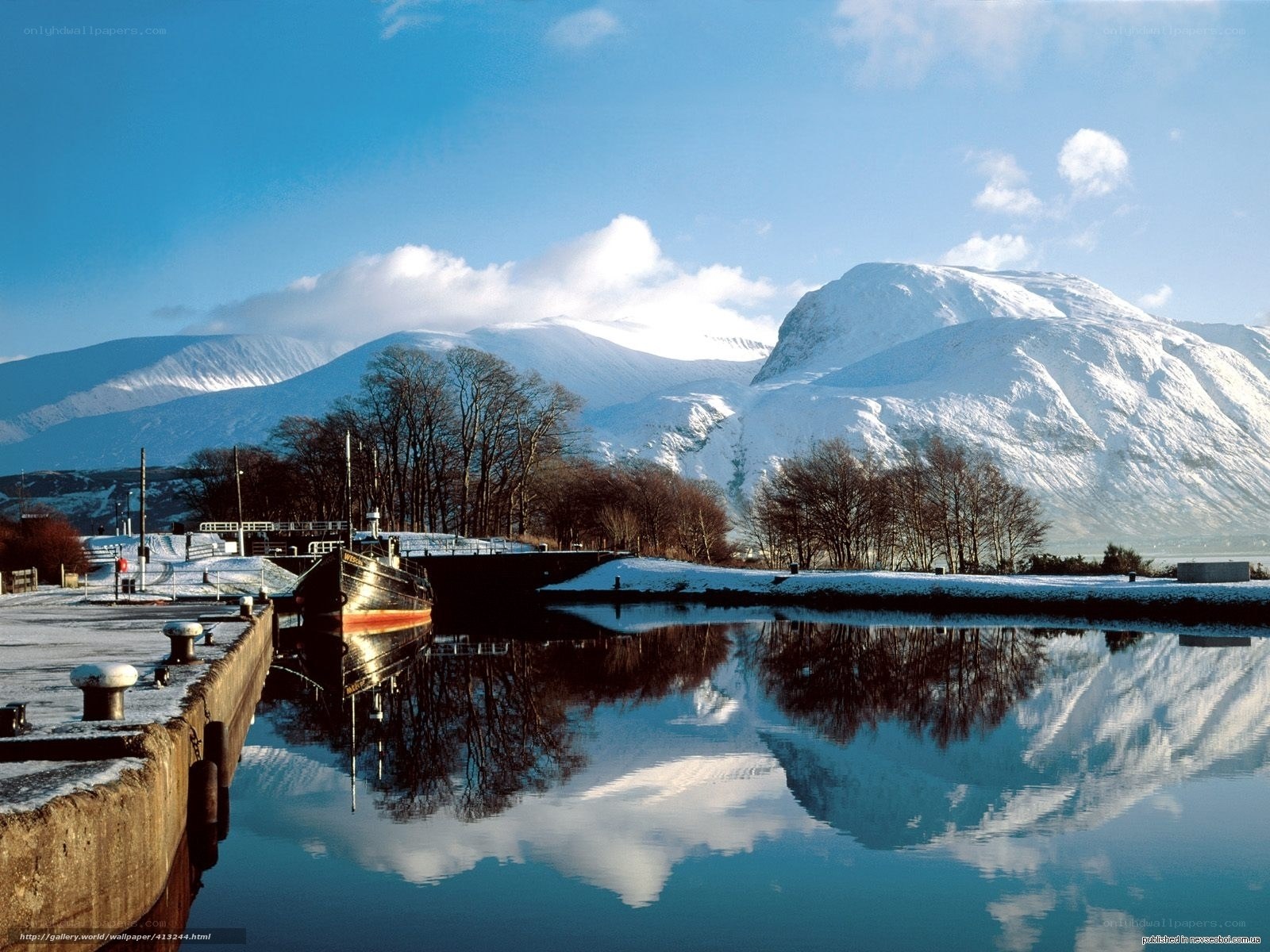 Snowy mountains reflect in canal