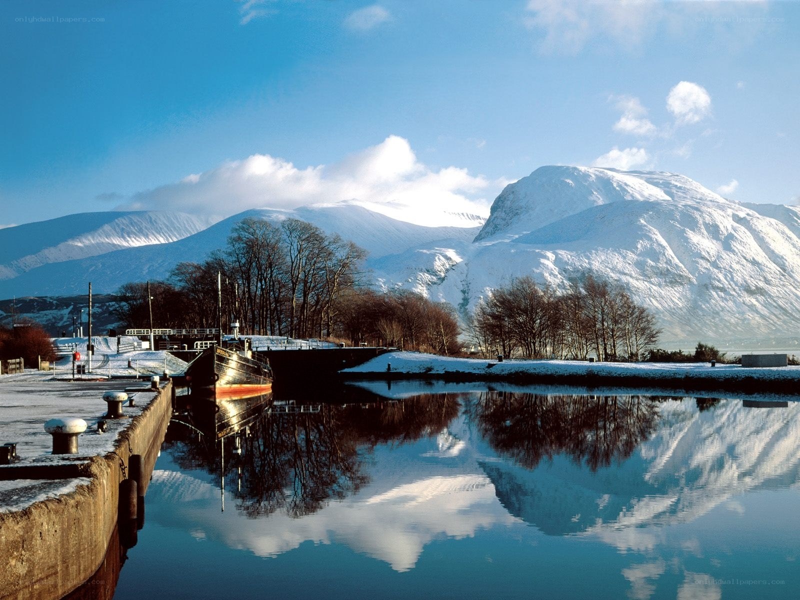 Snowy mountains reflect in canal