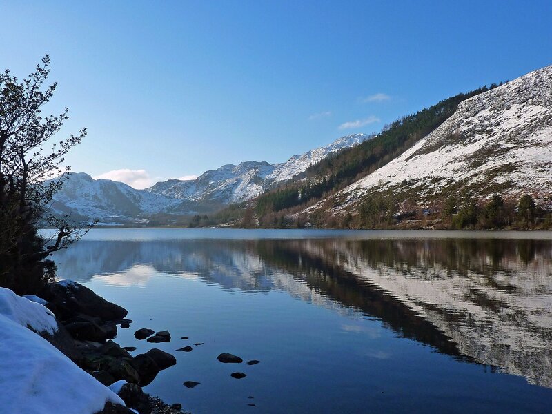 Snowy mountains reflect in lake