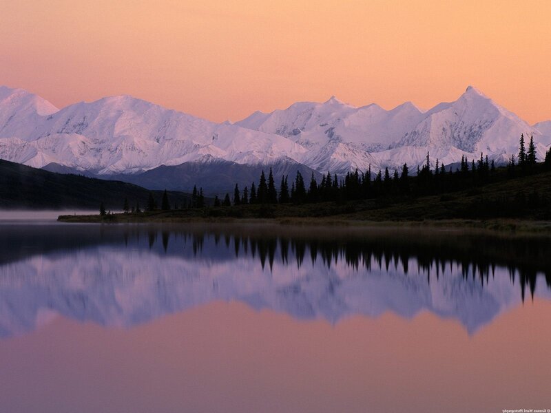 Snowy mountains reflect in lake