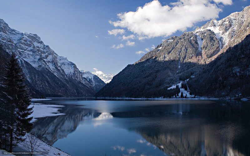 Snowy mountains reflect in lake