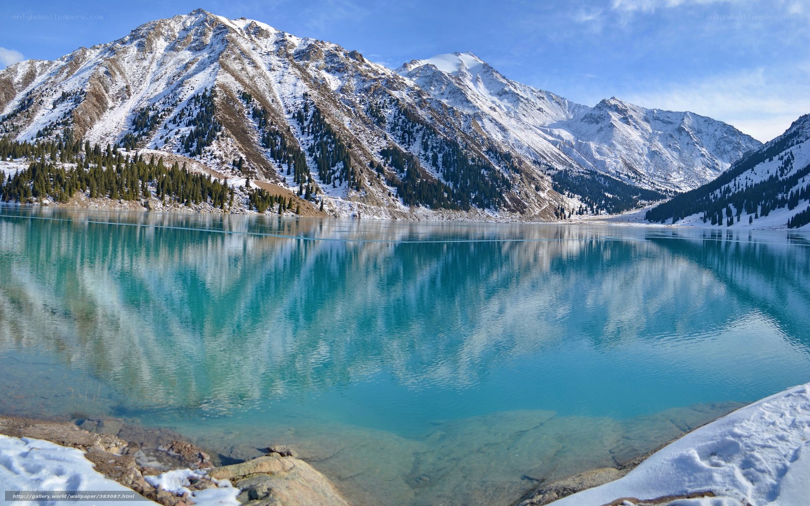 Snowy mountains reflect in turquoise lake