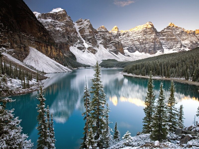 Snowy mountains reflect in turquoise lake