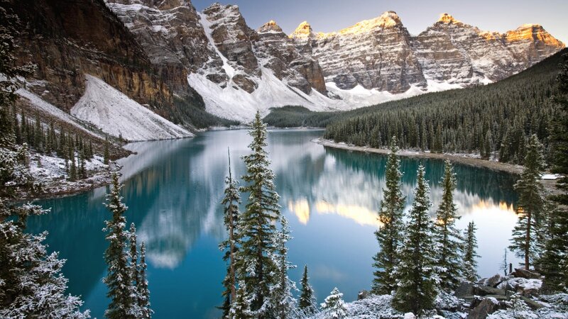 Snowy mountains reflect in turquoise lake