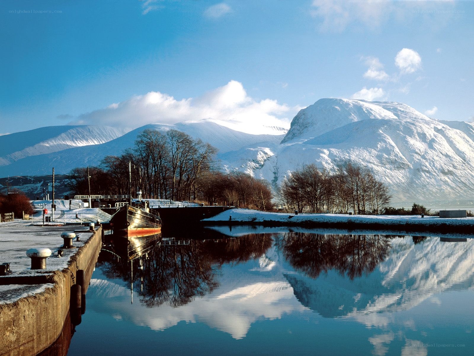 Snowy mountains reflected in a canal