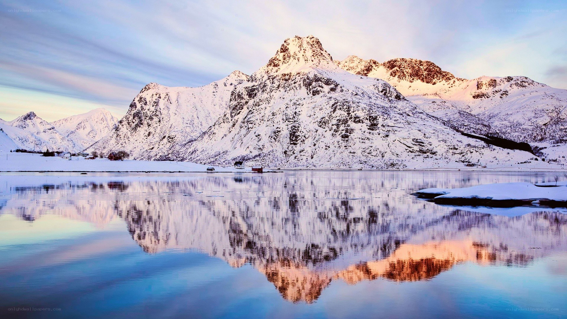 Snowy mountains reflected in calm water