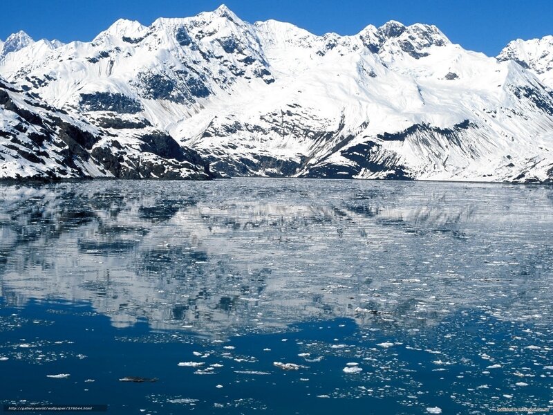 snowy mountains reflected in icy water