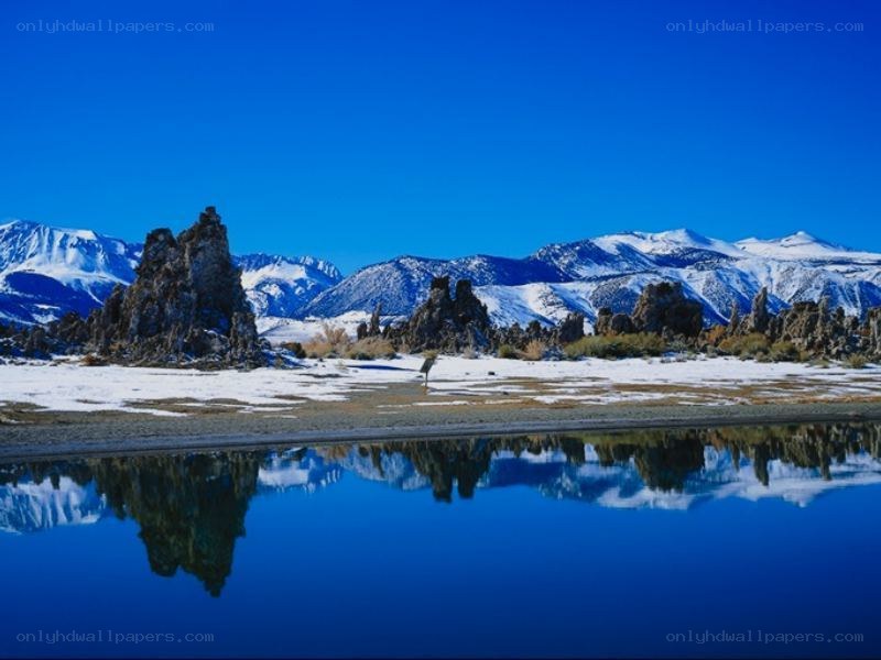 Snowy mountains reflected in lake
