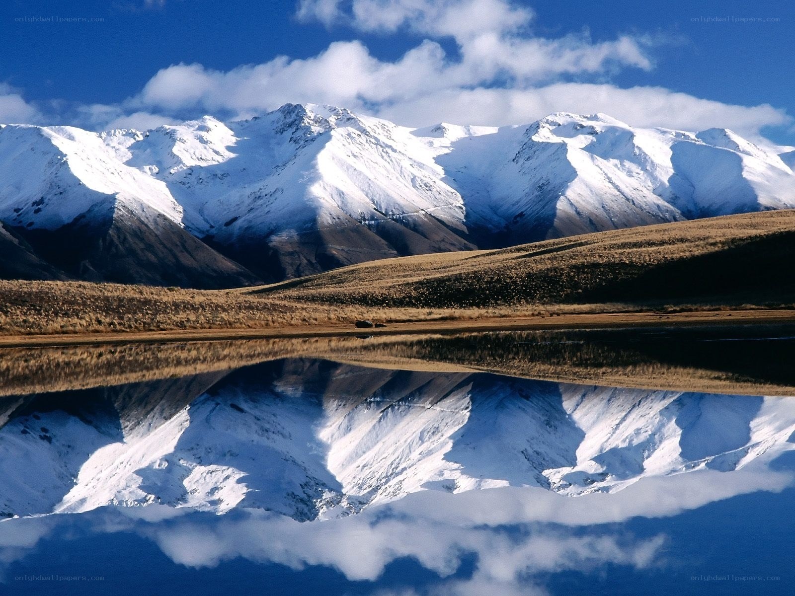 Snowy mountains reflected in lake