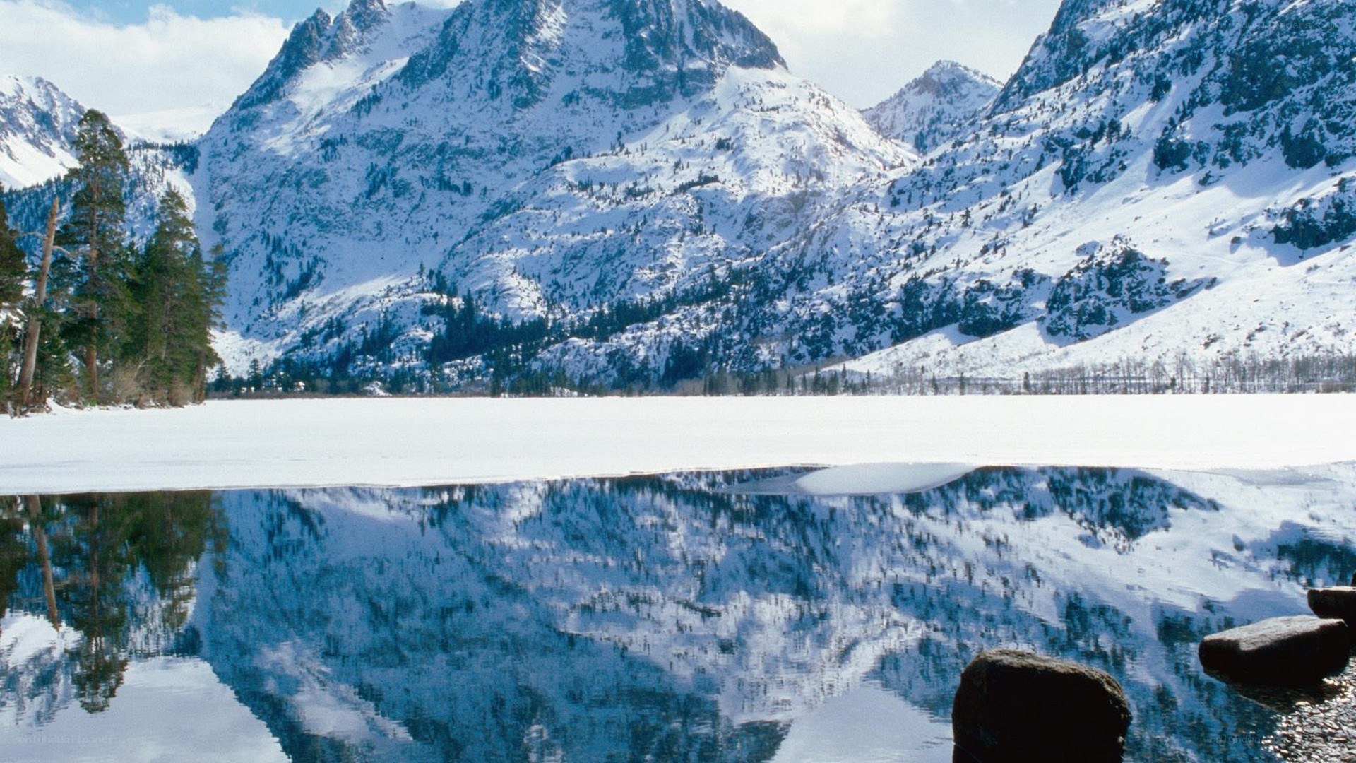 Snowy mountains reflected in lake