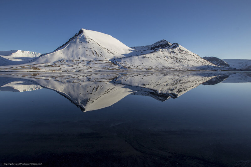 Snowy mountains reflected in water