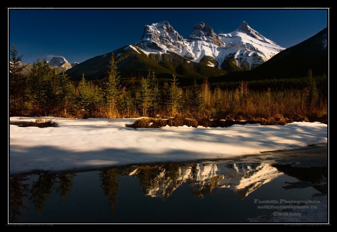 Snowy mountains reflected in water