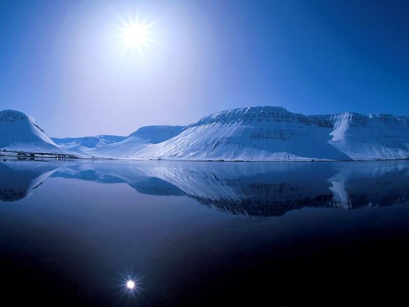 Snowy mountains reflected in water