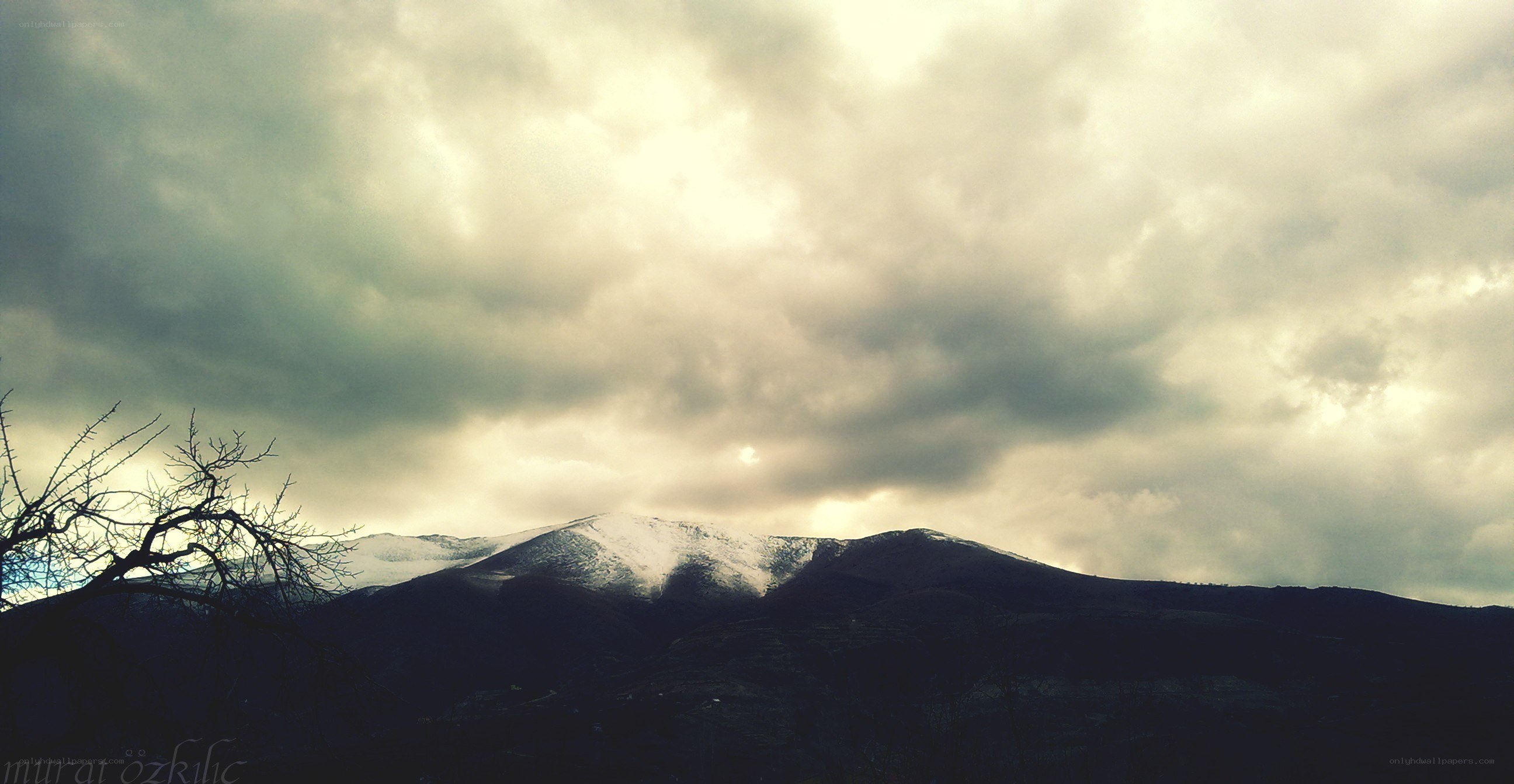 Snowy mountains under cloudy sky