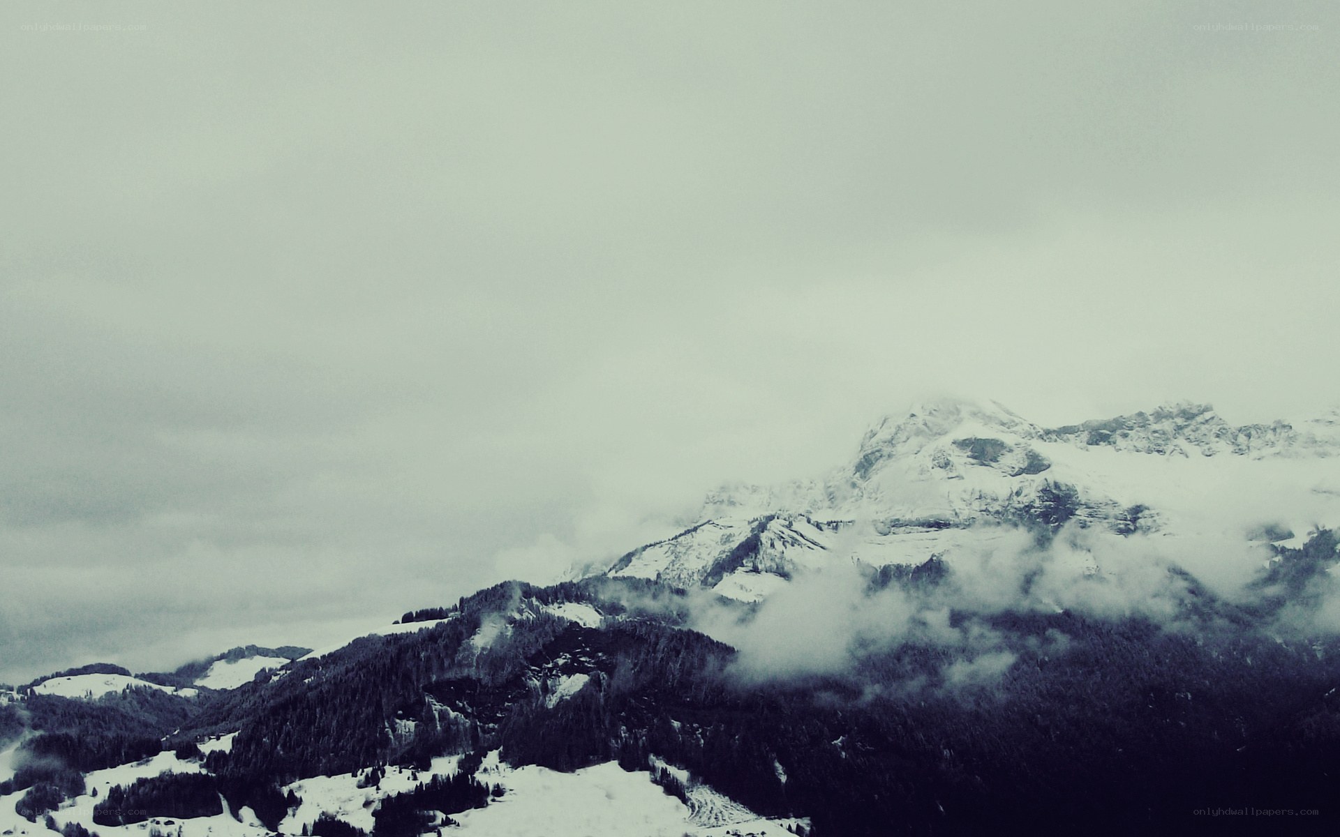 snowy mountains under cloudy sky