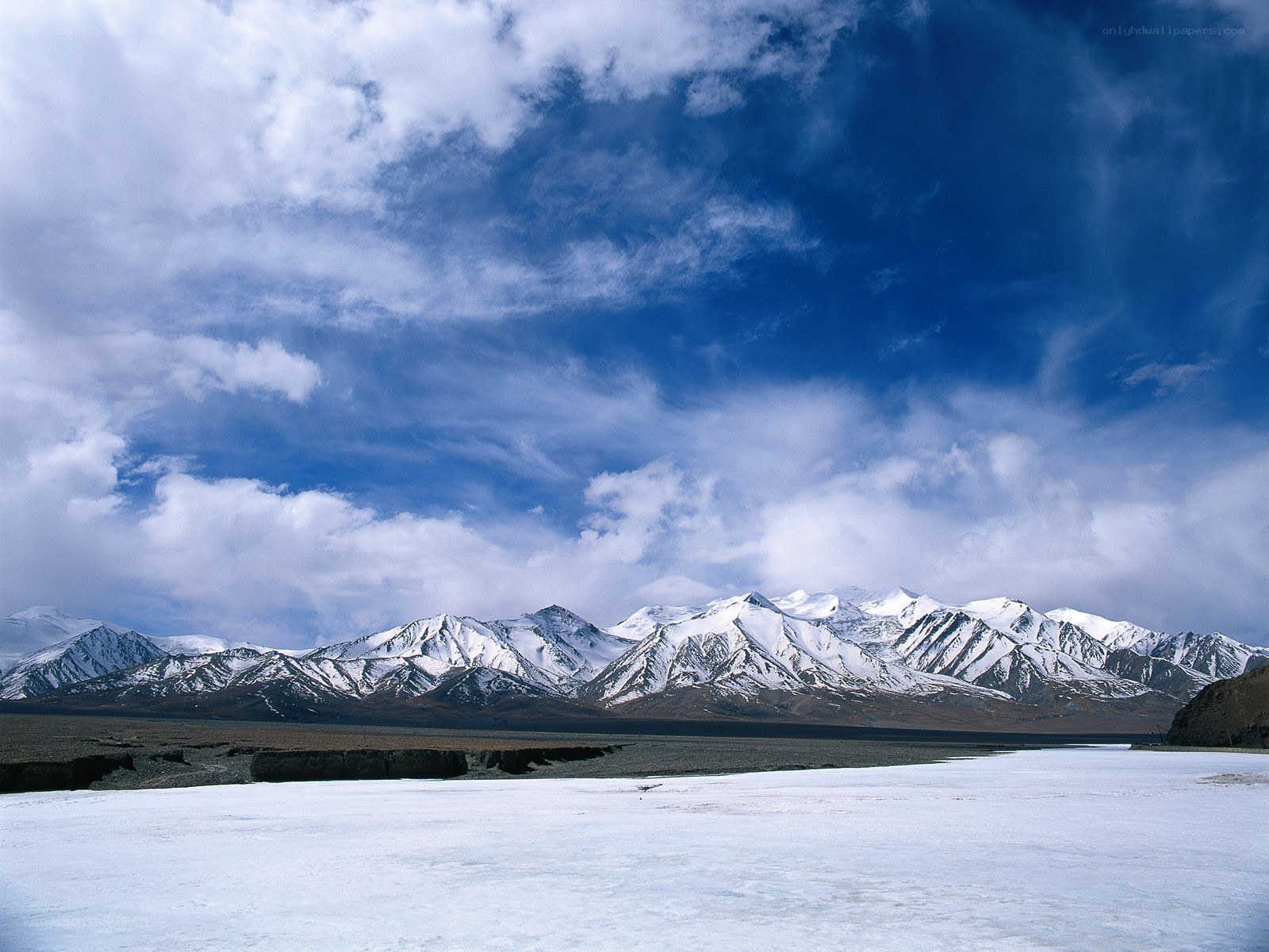 snowy mountains under cloudy sky