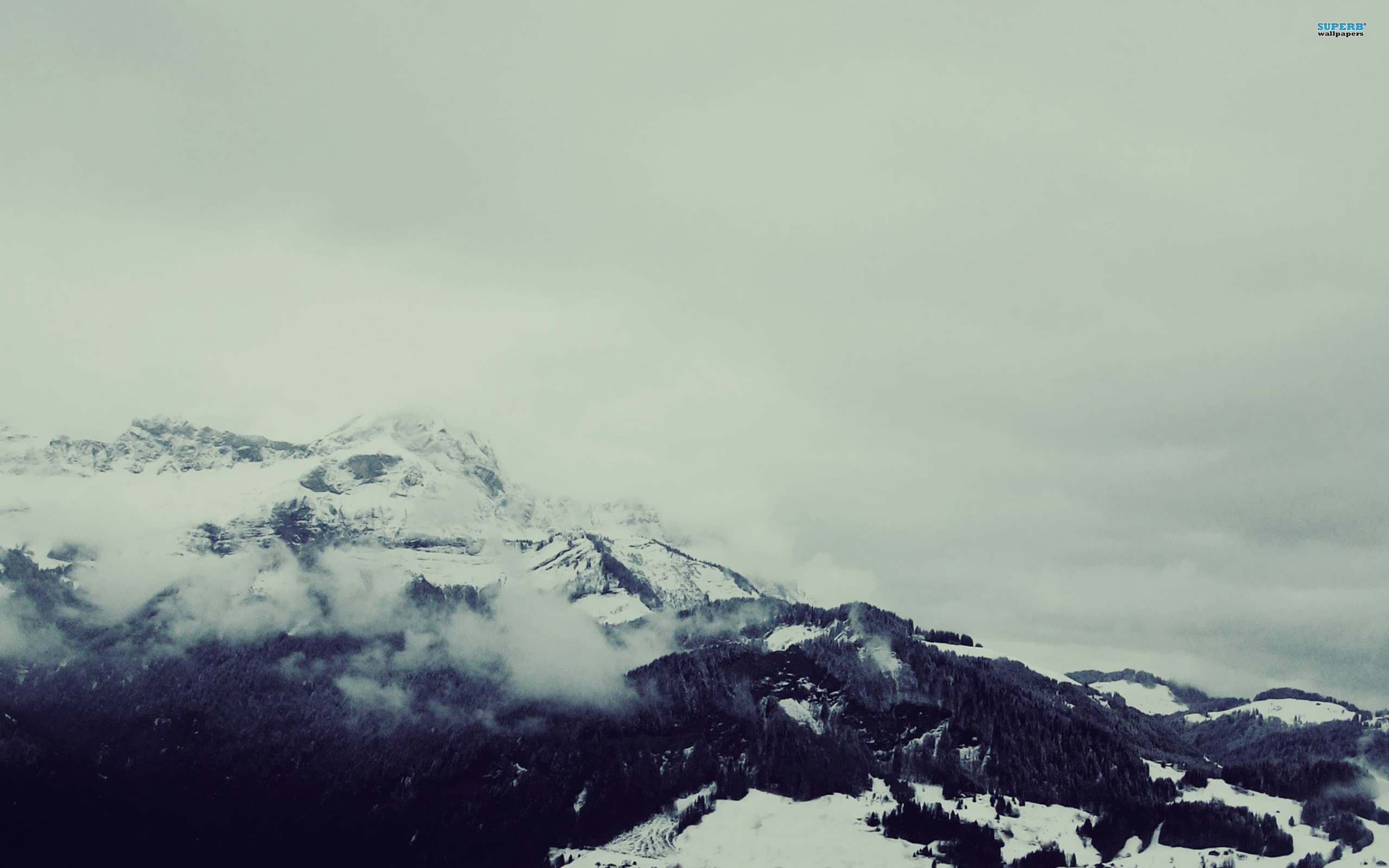 snowy mountains under cloudy sky