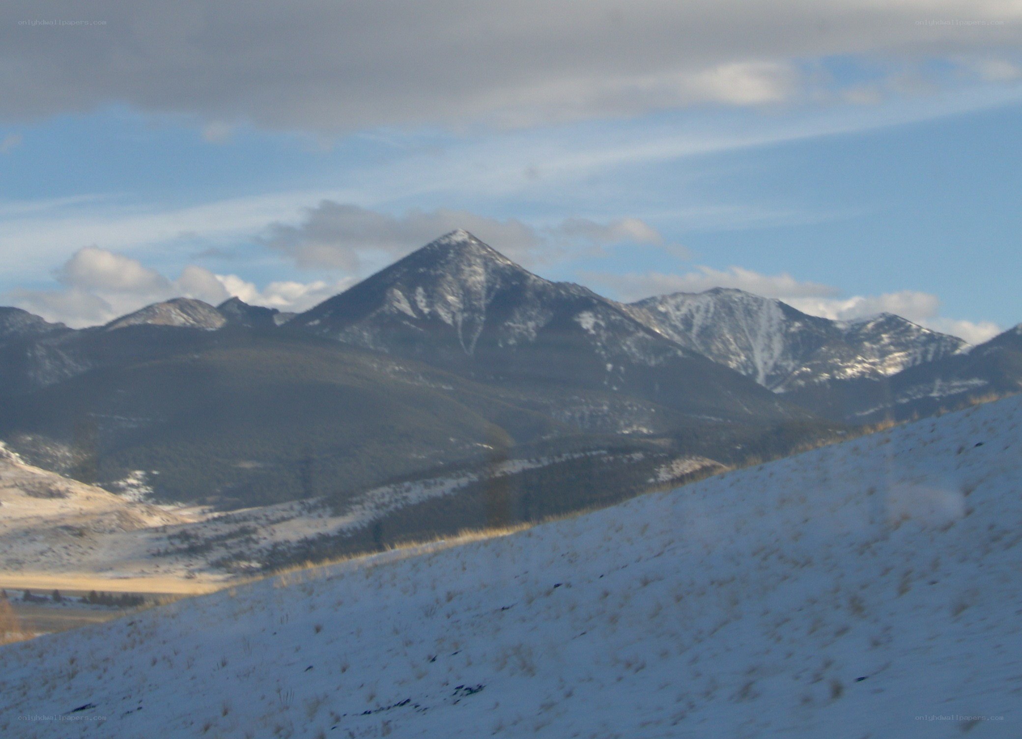 snowy mountains under cloudy sky