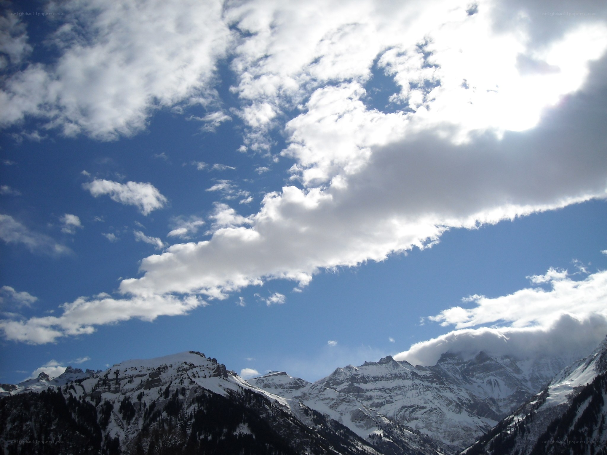 Snowy mountains under cloudy sky