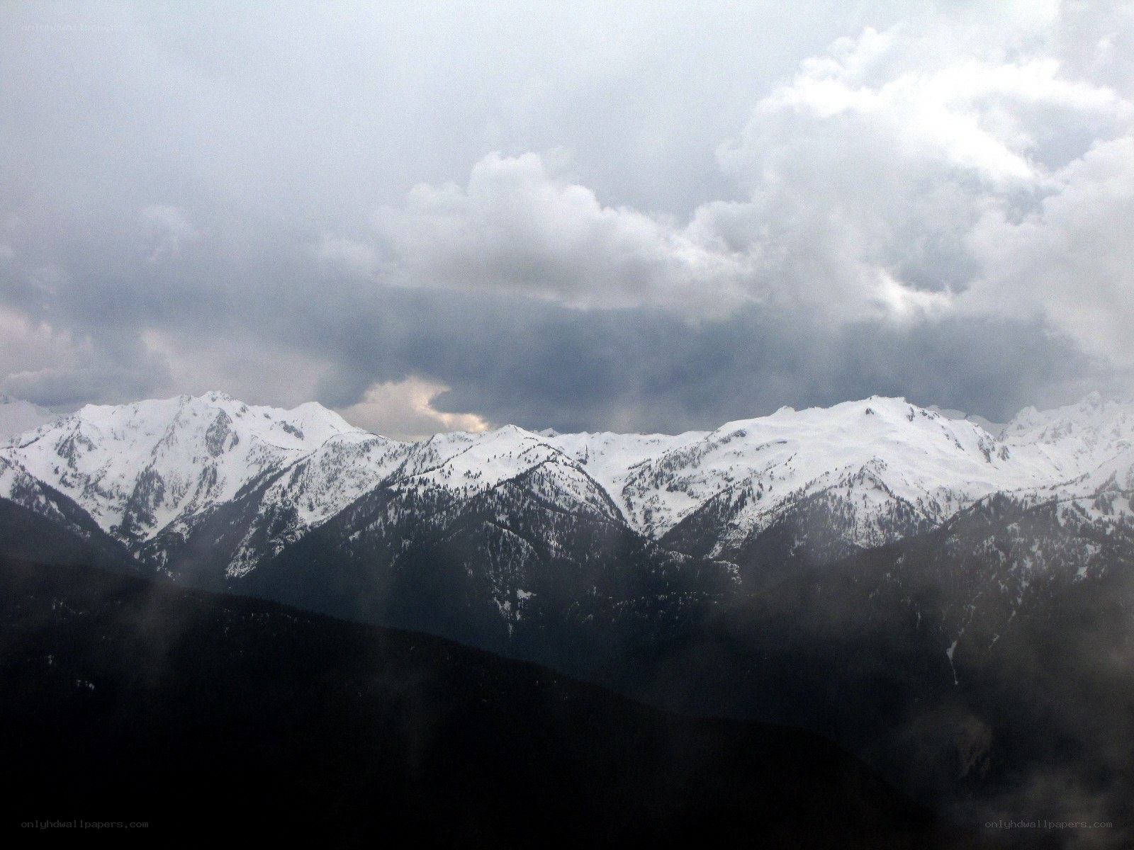 snowy mountains under cloudy sky