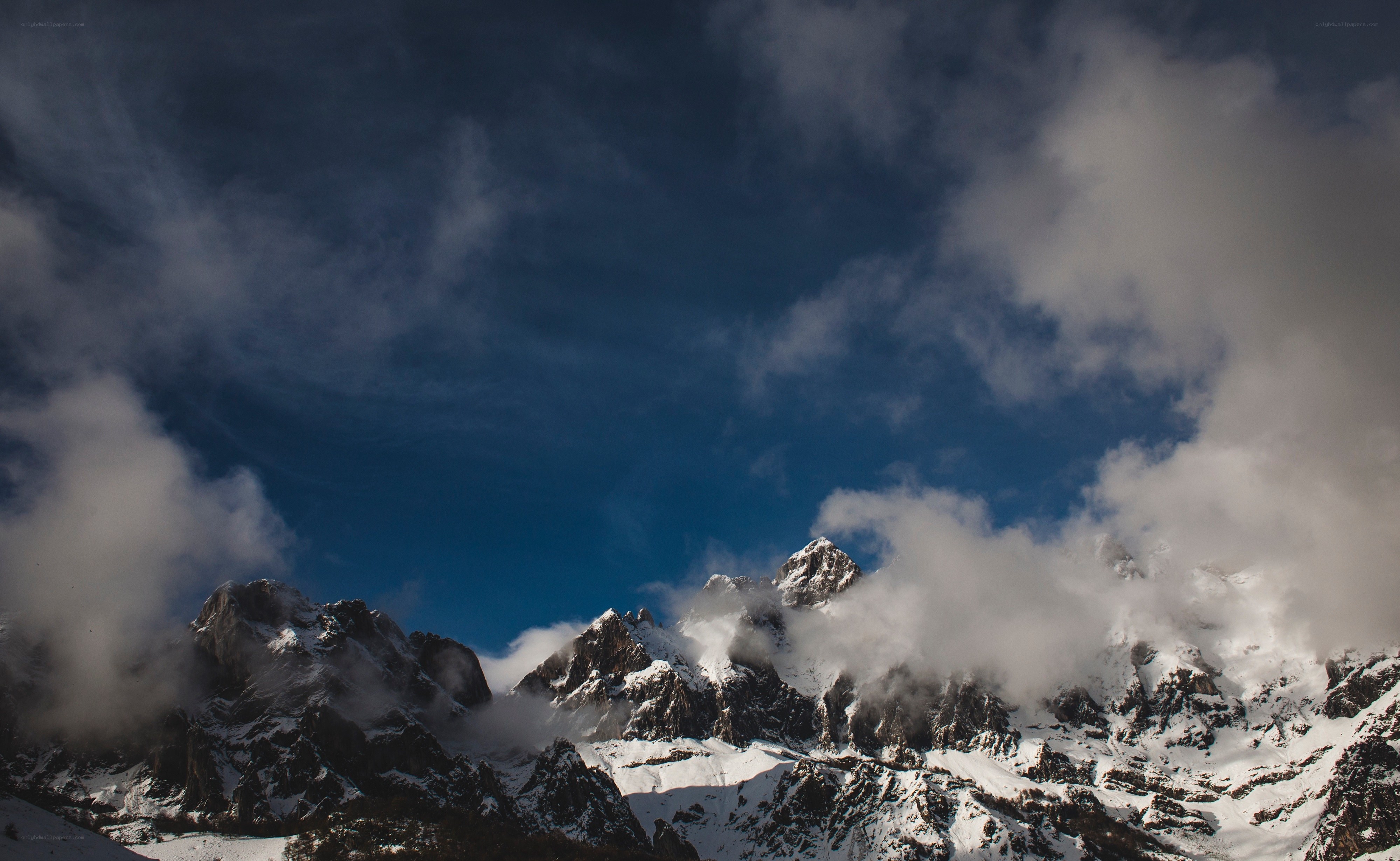 Snowy mountains under cloudy sky