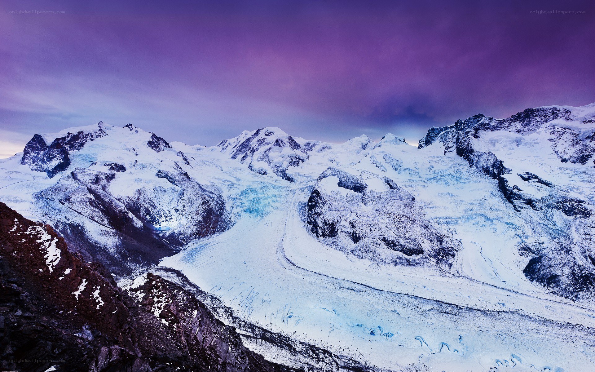 snowy mountains under purple sky