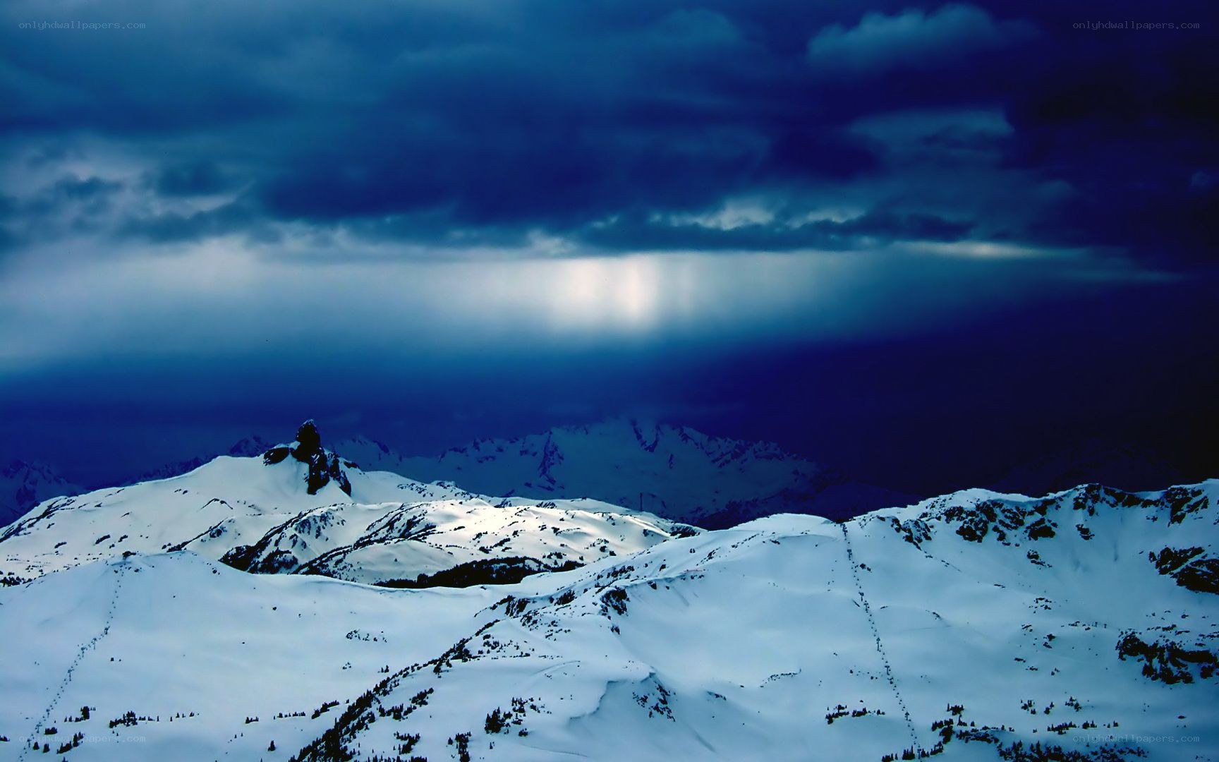 Snowy mountains under stormy sky