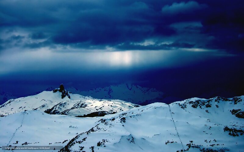 Snowy mountains under stormy sky