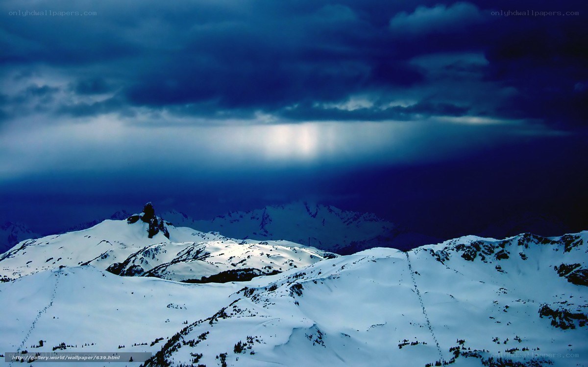Snowy mountains under stormy sky