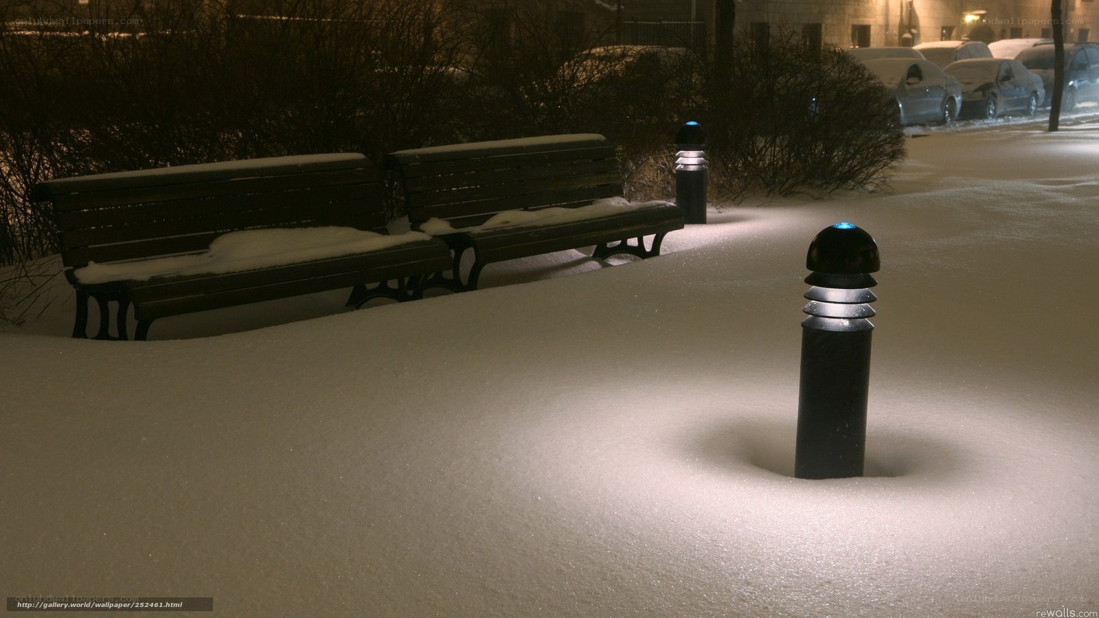 Snowy park benches at night