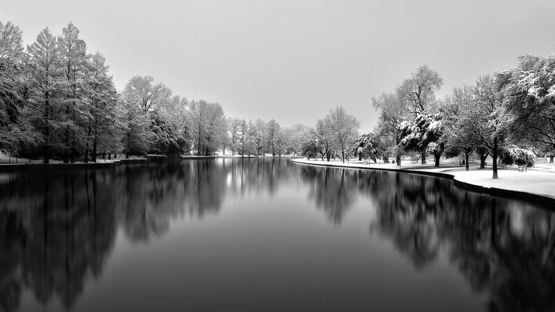 Snowy park lake reflection