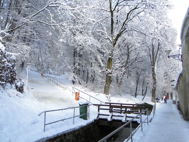 Snowy park path with bridge