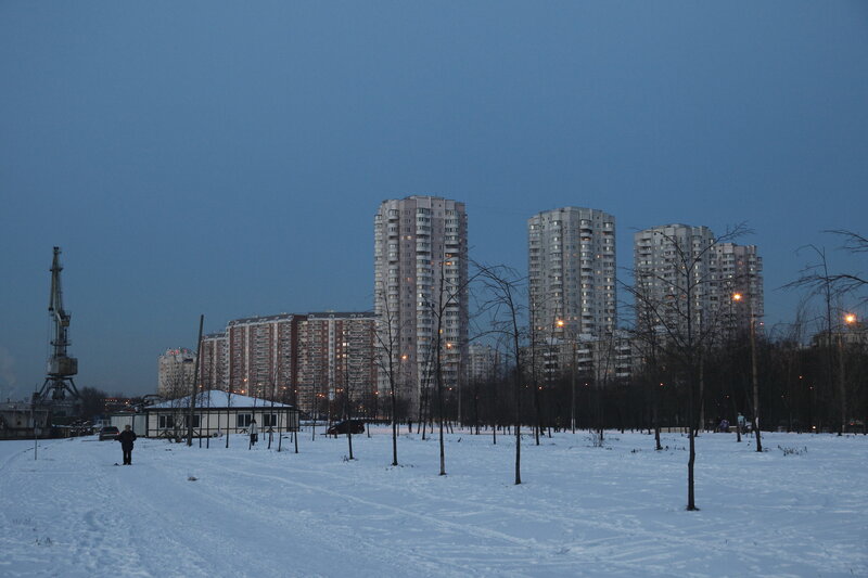 Snowy park with apartment buildings