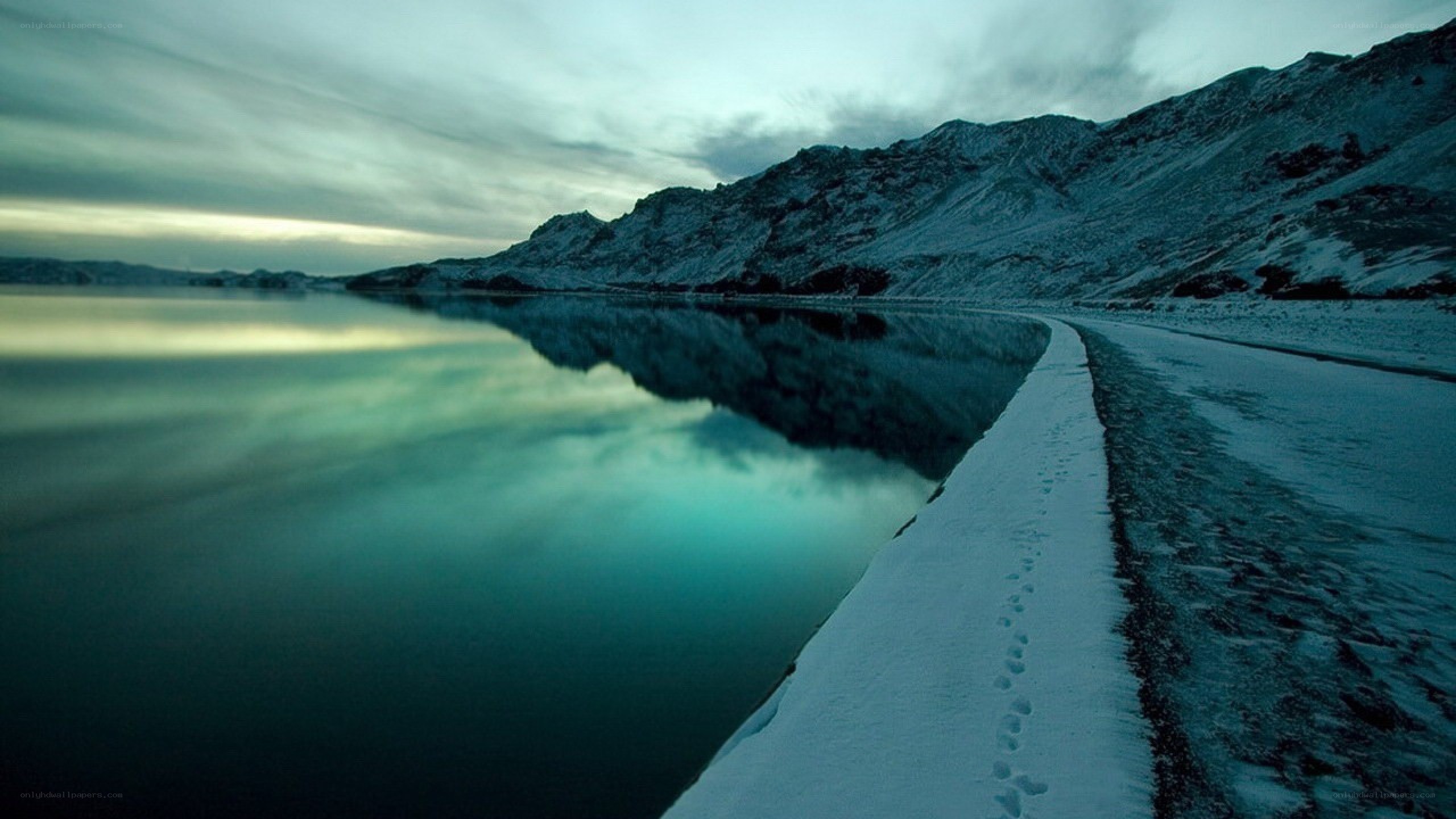 Snowy path by a calm lake
