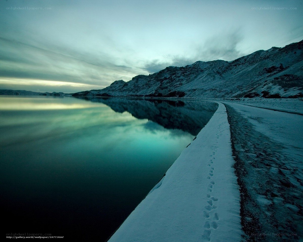 Snowy path by a calm lake