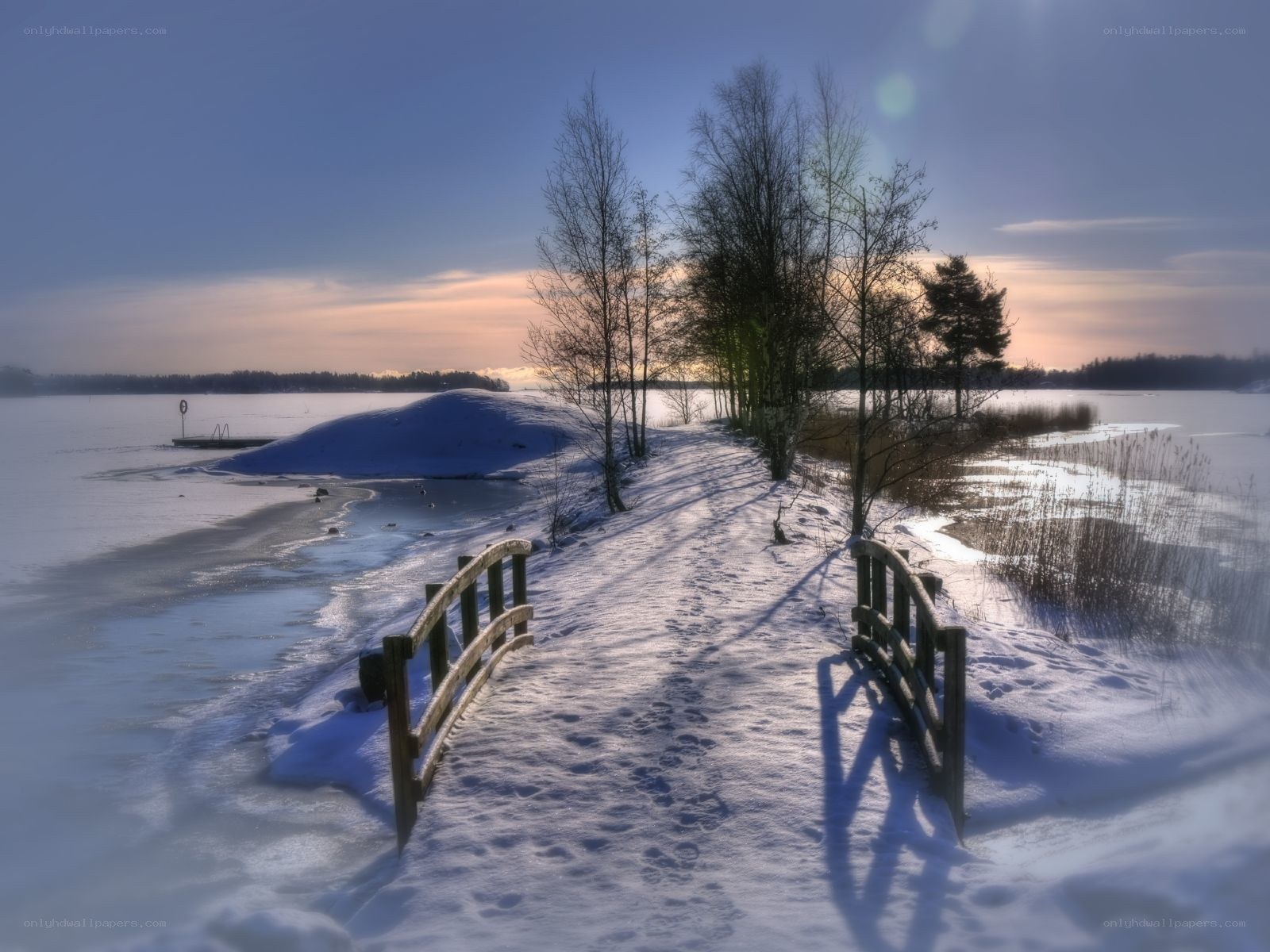 Snowy path by frozen lake