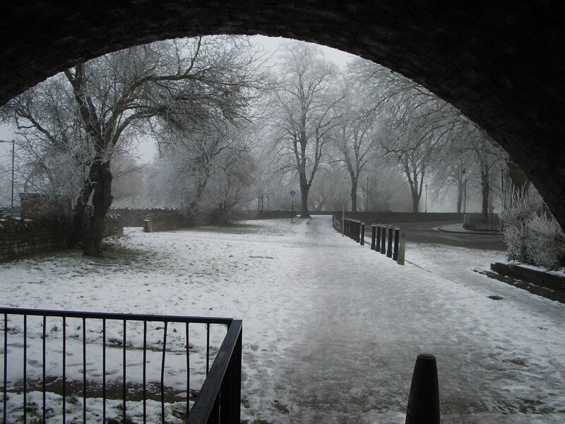 Snowy path under a bridge