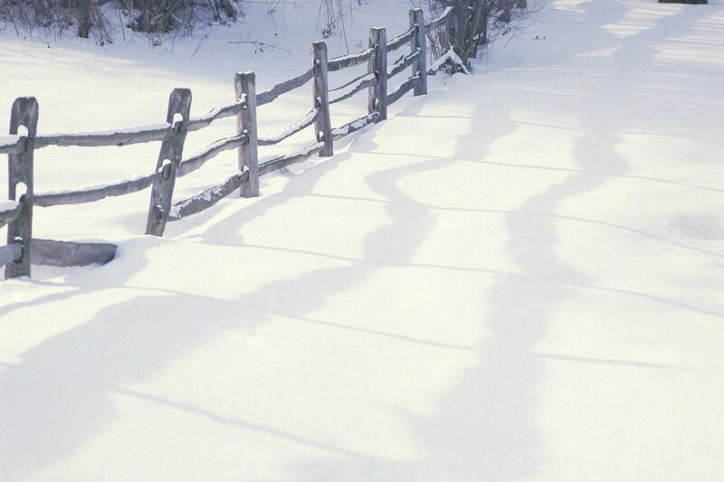 Snowy path with wooden fence
