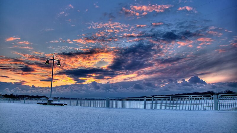 Snowy pier at sunset