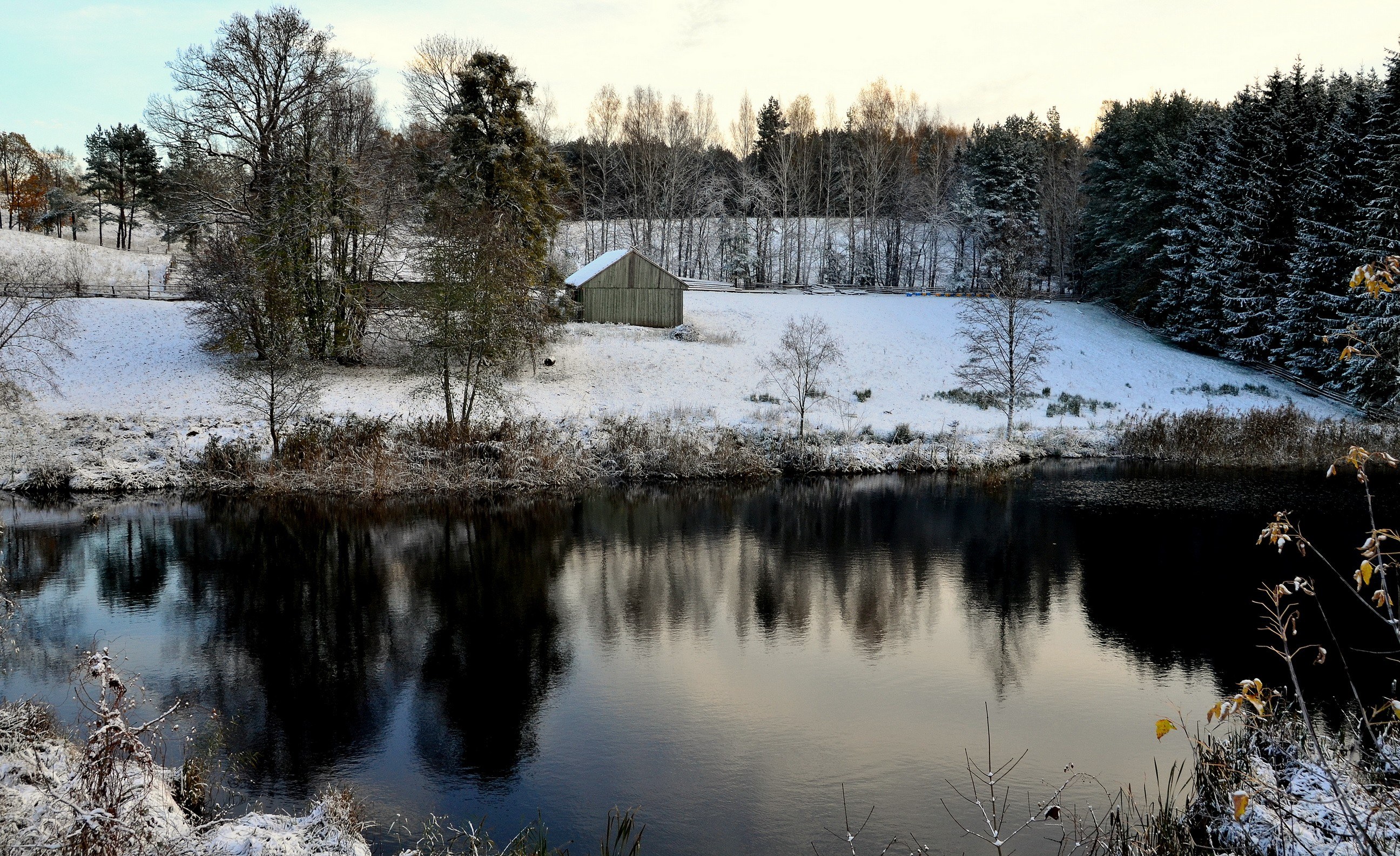 Snowy pond with barn reflection